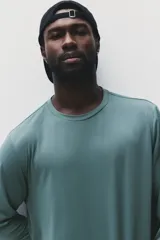 Remera deportiva de manga larga en tejido funcional con tecnología DryMove, diseñada para absorber el sudor y mantener la frescura durante el ejercicio. Presenta cuello redondo, corte estándar y aberturas laterales en el bajo.