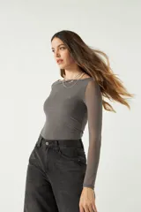 Top de manga larga confeccionado en tejido de tul con transparencias, de corte ajustado y cuello redondo.