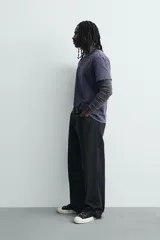 Camiseta de corte relajado con cuello redondo y manga corta. Presenta un acabado con efecto lavado que le otorga una apariencia única y desgastada. Incluye estampados a contraste en la parte frontal.