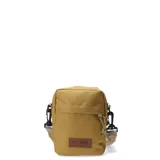 Morral pequeño color mostaza, con cierre frontal y correa ajustable. Presenta un parche de cuero sintético con el logo de la marca en la parte inferior.