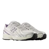 Championes New Balance modelo 740, de diseño técnico con base de malla blanca y superposiciones sintéticas en tono plateado con detalles en violeta. Cuenta con entresuela con tecnología ABZORB para amortiguación, logo N lateral en TPU y suela de goma resistente.