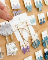 Aros colgantes dorados con forma de círculo y una barra vertical que lo atraviesa.