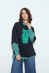 Remerón de manga corta con calce amplio y estética urbana, confeccionado con proceso de lavado que le otorga un efecto desgastado. Presenta una estampa gráfica frontal de un oso de goma en color verde.