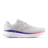 Championes de running New Balance modelo Fresh Foam X Evoz V4, color gris claro con detalles en violeta y rosado en la entresuela. Presentan capellada de malla transpirable, logo lateral característico y tecnología de amortiguación Fresh Foam X.