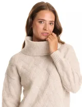 Buzo de punto grueso con textura en relieve, de cuello volcado y mangas largas con hombros caídos. Presenta puños y ruedo con terminación en rib.