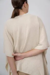 Ruana color crudo de tejido de punto con textura, hecha de 100% baby alpaca.