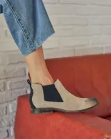 Botinetas tipo chelsea con paneles laterales elásticos en color negro. Presentan un acabado texturizado en tono claro con efecto desgastado y suela plana con pequeño tacón.