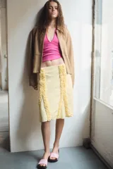 Blazer de cuero color beige con cuello solapa, manga larga y cierre frontal con cremallera y botones a presión ocultos. Presenta bolsillos laterales ocultos en costura y forro interior.