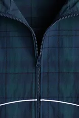 Campera deportiva de nylon en color verde oscuro con estampado a cuadros, cuello elevado, cierre frontal y ribetes blancos en contraste. Cuenta con elástico en puños y bajo, y forro de malla.