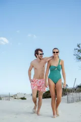 Short de baño blanco con estampado de hojas y flores rojas, cintura elástica con cordón blanco.