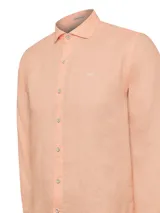Camisa de hombre color salmón, de lino orgánico, manga larga, calce regular, con cuello clásico y cierre con botones.