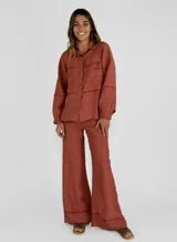 Pantalón palazzo color ladrillo, de tiro alto y corte amplio. Confeccionado en lino.