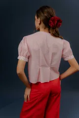 Blusa de algodón a rayas rosadas y blancas, con mangas cortas abullonadas, cuello mao y detalles de tela estampada floral en la botonera y los puños.