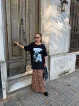 Conjunto compuesto por un remerón negro de algodón con estampa fotográfica frontal y una pollera midi de satén con estampado animal print de leopardo.