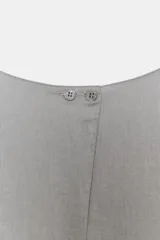 Vestido midi de Zara Woman Collection confeccionado en hilatura con lino, color gris. Presenta cuello redondo, manga corta caída, detalle de frunces y lazadas laterales en el mismo tejido, y cierre en la espalda.
