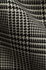 Vestido corto con estampado a cuadros en blanco y negro, escote en V y mangas cortas.