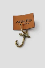 Arete tipo argolla de metal color bronce envejecido con un dije colgante con forma de la letra 'J' con textura orgánica y rústica.