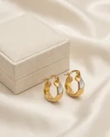 Aros tipo argolla pequeña con diseño de superficie texturizada y acabado bicolor en tono dorado y plateado.