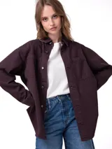 Camisa oversize de pana color bordó, de manga larga con puños abotonados, cierre frontal de botones y bolsillos dobles en el pecho.