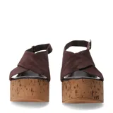Sandalias de plataforma alta estilo cuña fabricadas en corcho. Presentan tiras cruzadas en el empeine de gamuza color marrón oscuro y cierre mediante pulsera con hebilla metálica al tobillo.