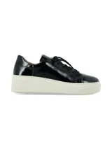 Sneaker Adelaida de suela elevada, confeccionado en cuero charol negro con cordones de algodón al tono y suela chunky de goma blanca.