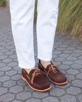 Zapato náutico de cuero gamuzado color marrón chocolate, con cordones y suela plana.