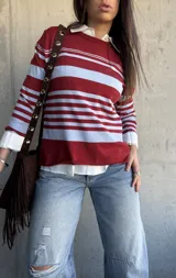 Sweater fluido de punto con diseño de rayas horizontales en color bordó y celeste, de manga larga y cuello redondo.