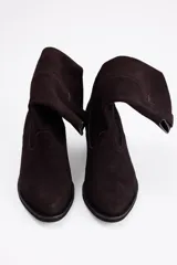 Bota de caña media estilo western, confeccionada en cuero vacuno con acabado de gamuza en color marrón, con taco cuadrado y puntera redondeada.