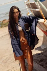 Camisa de lino azul marino de manga larga con botones claros y un bolsillo frontal de pelo de vaca con patrón marrón y blanco.