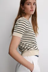 Jersey de punto de manga corta con cuello redondo, a rayas horizontales blancas y negras.