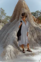 Vestido camisero midi color gris claro, de corte amplio, con cuello camisero, mangas 3/4 y cierre frontal con botones.