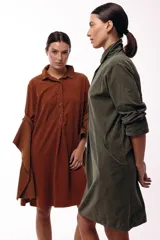 Vestido camisero de silueta amplia y fluida, color verde militar, con cuello camisero, frente abotonado parcial, mangas largas y bolsillos laterales.