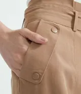 Pantalón cargo color beige, de corte recto, con cintura alta y cinturón con hebilla.