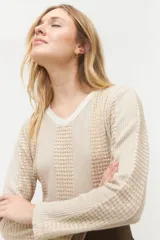 Blusa de punto color beige con escote en V, manga larga y diseño de textura con cortes verticales.