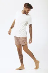 Short de baño salmón con estampado de tablas de surf, cordón ajustable en la cintura y etiqueta lateral de la marca.