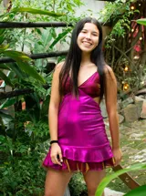 Vestido corto color bordó con escote en V, diseño de top triangular y aberturas laterales en la cintura. Presenta breteles finos cruzados en la espalda y falda con doble volado irregular en el ruedo.
