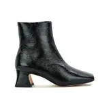 Bota corta de cuero charol negro con punta cuadrada y taco geométrico.