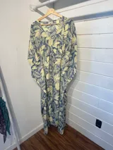 Kaftan largo con estampado floral en tonos turquesa y fucsia, con detalles de guarda pampa en los bordes.