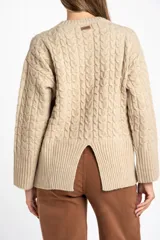 Sweater de punto con diseño de trenzas verticales, cuello redondo y corte oversize. Presenta puños y ruedo acanalados anchos.