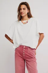 Remera de jersey de algodón blanca con silueta murciélago, escote barco y mangas dolman muy anchas de corte recto y holgado.