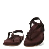 Sandalias de cuero marrón, tipo thong con tira separadora de dedos y cierre con tira ajustable en el talón.