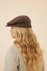 Boina con visera de lana fina uruguaya natural, sin teñir, con diseño de tejido texturizado en tonos beige y marrón.