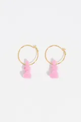 Aros de aro pequeño en color dorado con un dije colgante en forma de conejo de color blanco con acabado flocado.