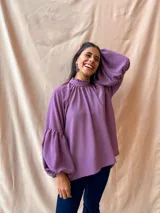 Blusa verde con cuello alto fruncido y mangas largas abullonadas.