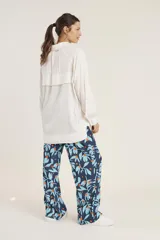 Camisa blanca de manga larga con cuello clásico y cierre frontal con botones.