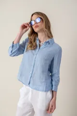 Camisa color coral de lino con cuello clásico, manga 3/4 y cierre frontal con botones.