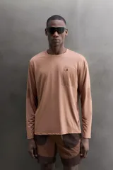 Camiseta de entrenamiento de manga larga Zara Athleticz de color marrón, corte regular fit y cuello redondo. Está confeccionada en tejido técnico elástico de secado rápido y cuenta con un bolsillo en el pecho con cierre de cremallera.