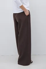 Pantalon de corte sastrero y pierna ancha, confeccionado en tela melange. Presenta cintura con trabillas, cierre frontal con botón y bolsillos laterales.