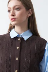 Chaleco tejido de punto color marrón oscuro, con botones frontales y diseño de punto calado vertical.