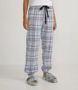 Pantalón de pijama largo de franela con estampado a cuadros, cintura elástica con lazo y tobillos elastizados.